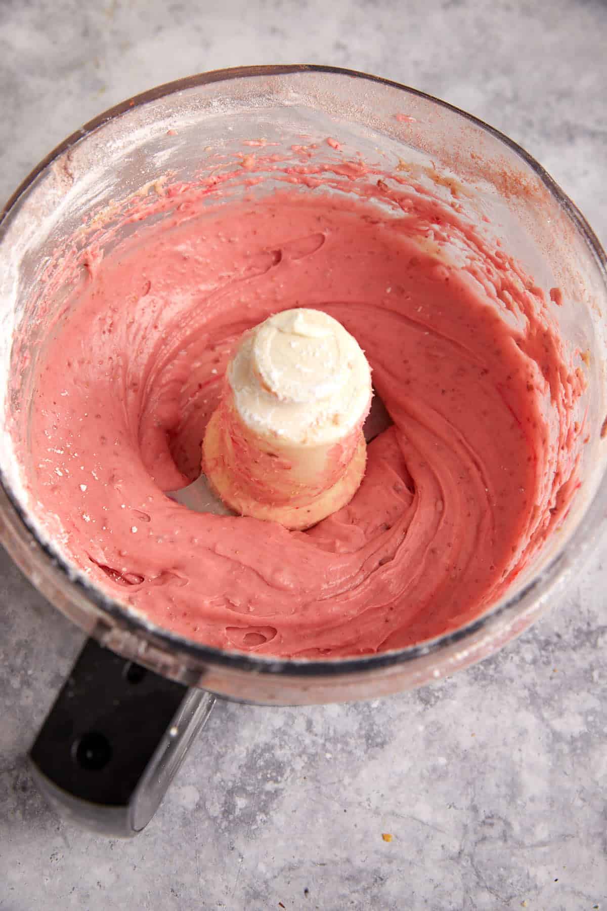 Strawberry frosting mixed in a food processor.