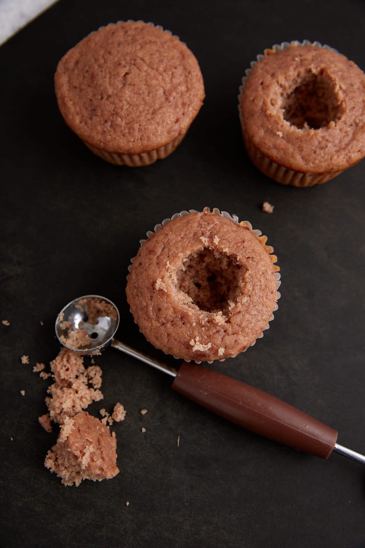 A melon baller used to remove the core of a cupcake.