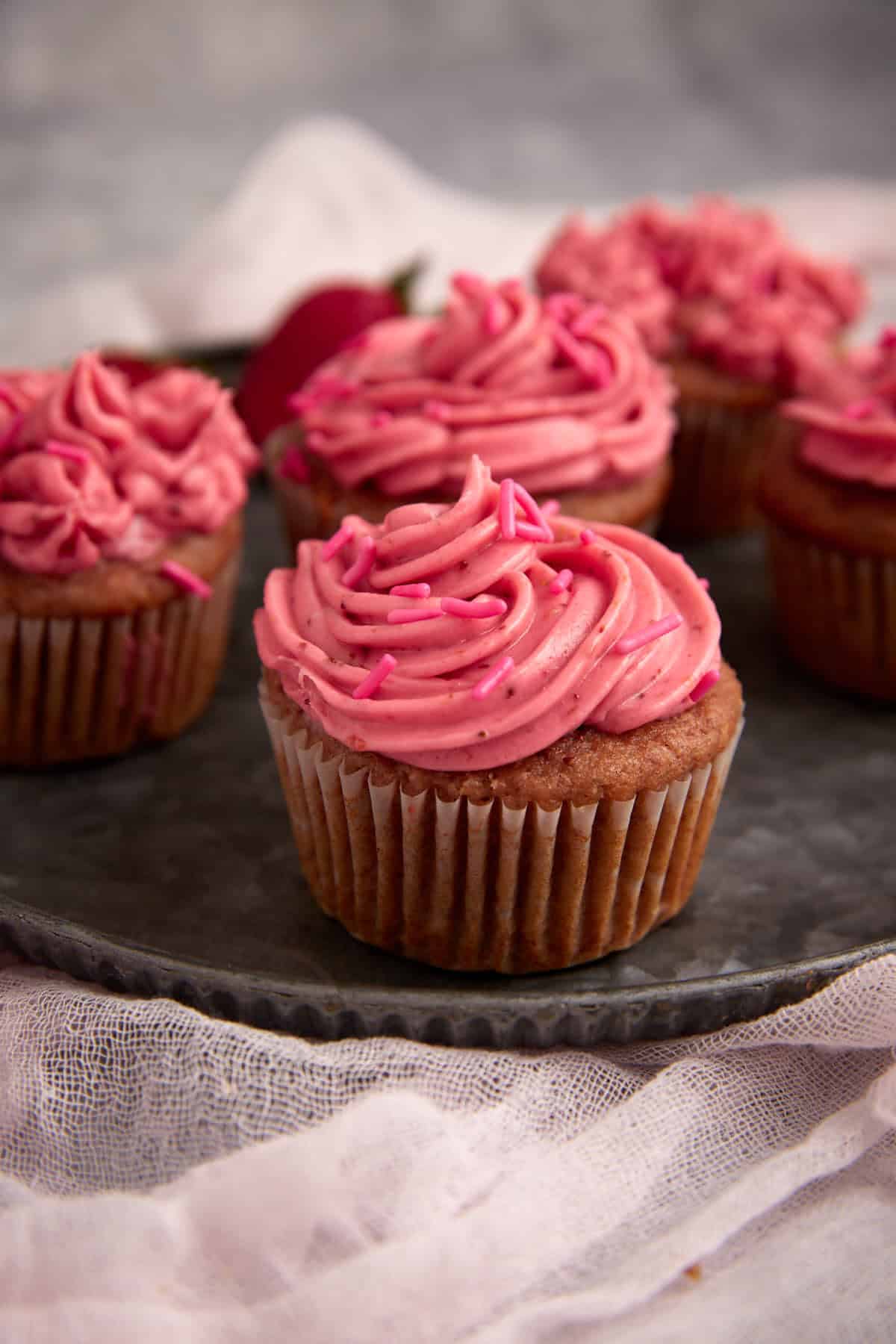 Strawberry cupcakes frosted with strawberry frosting.