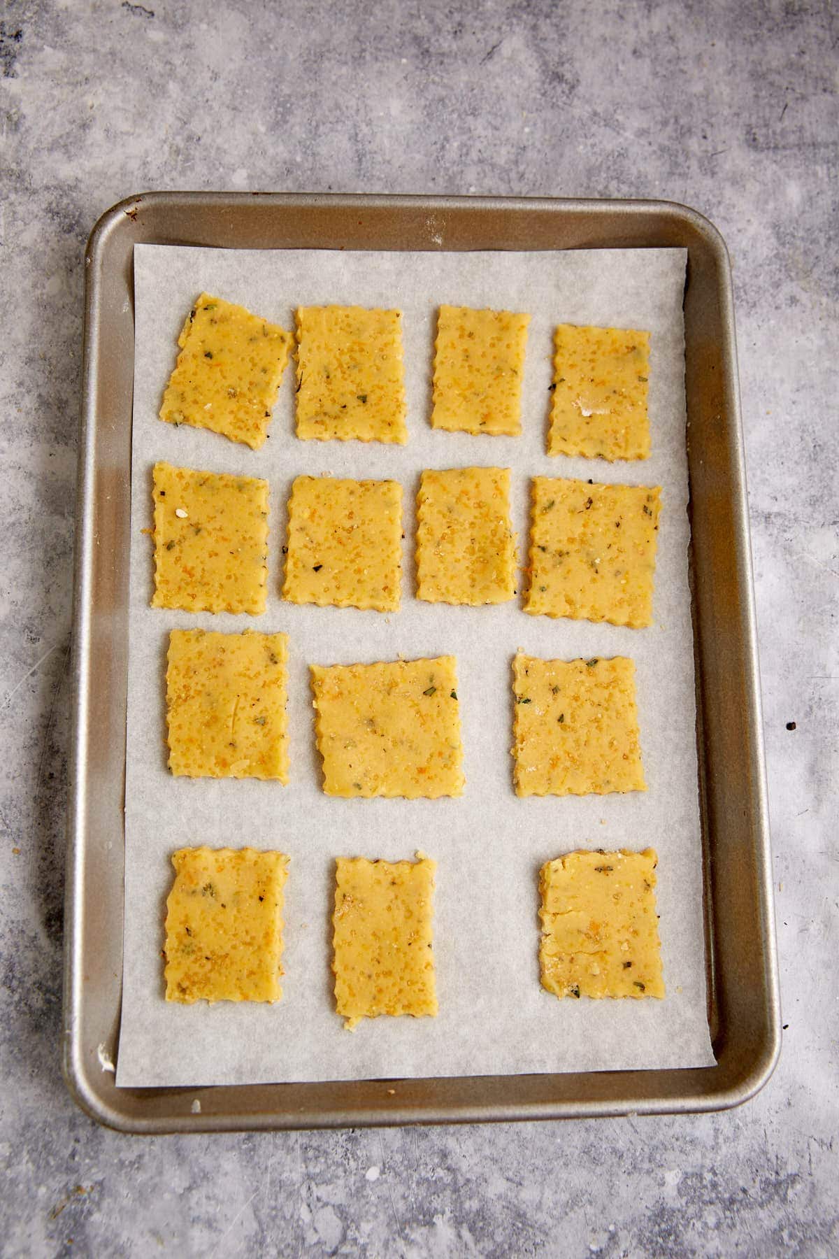 shortbread dough cut into squares on a baking sheet.