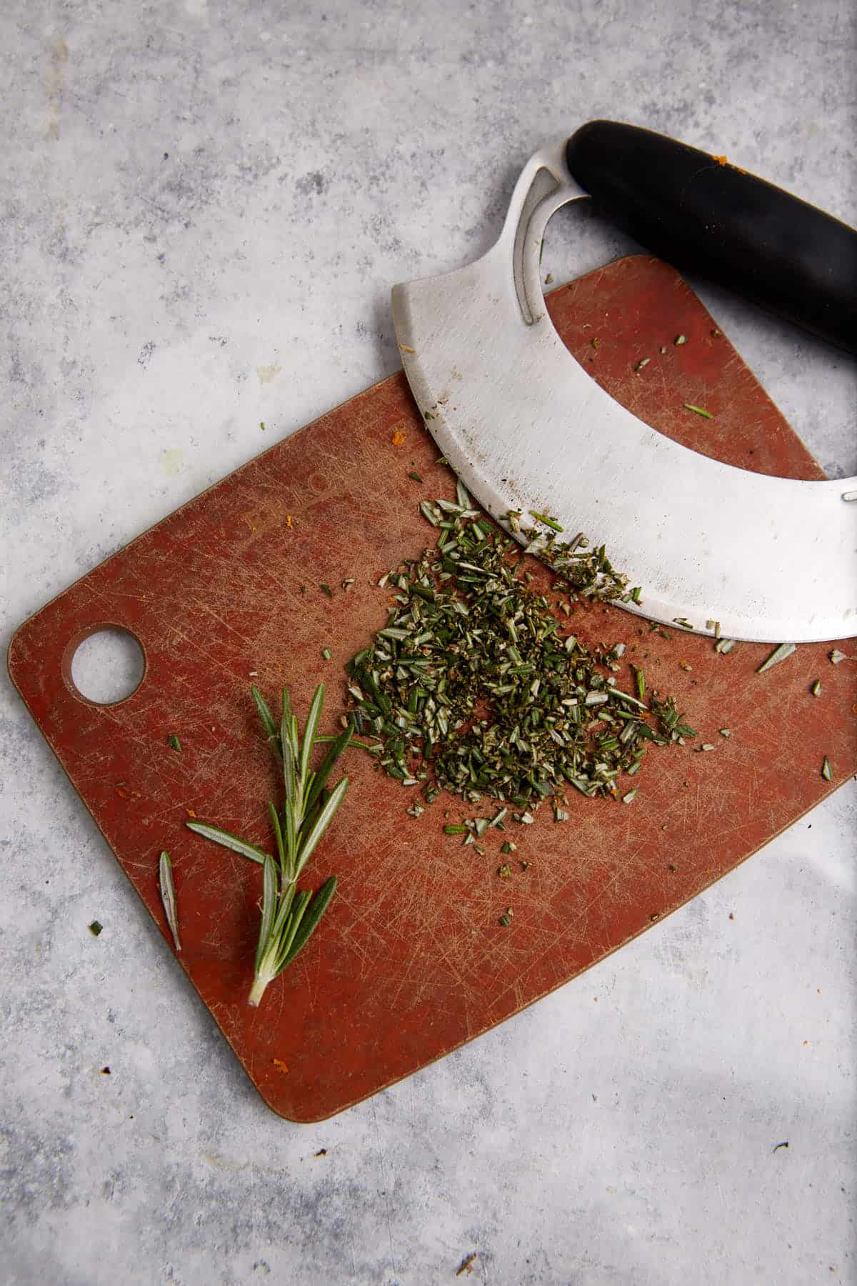 Rosemary chopped on a cutting board.
