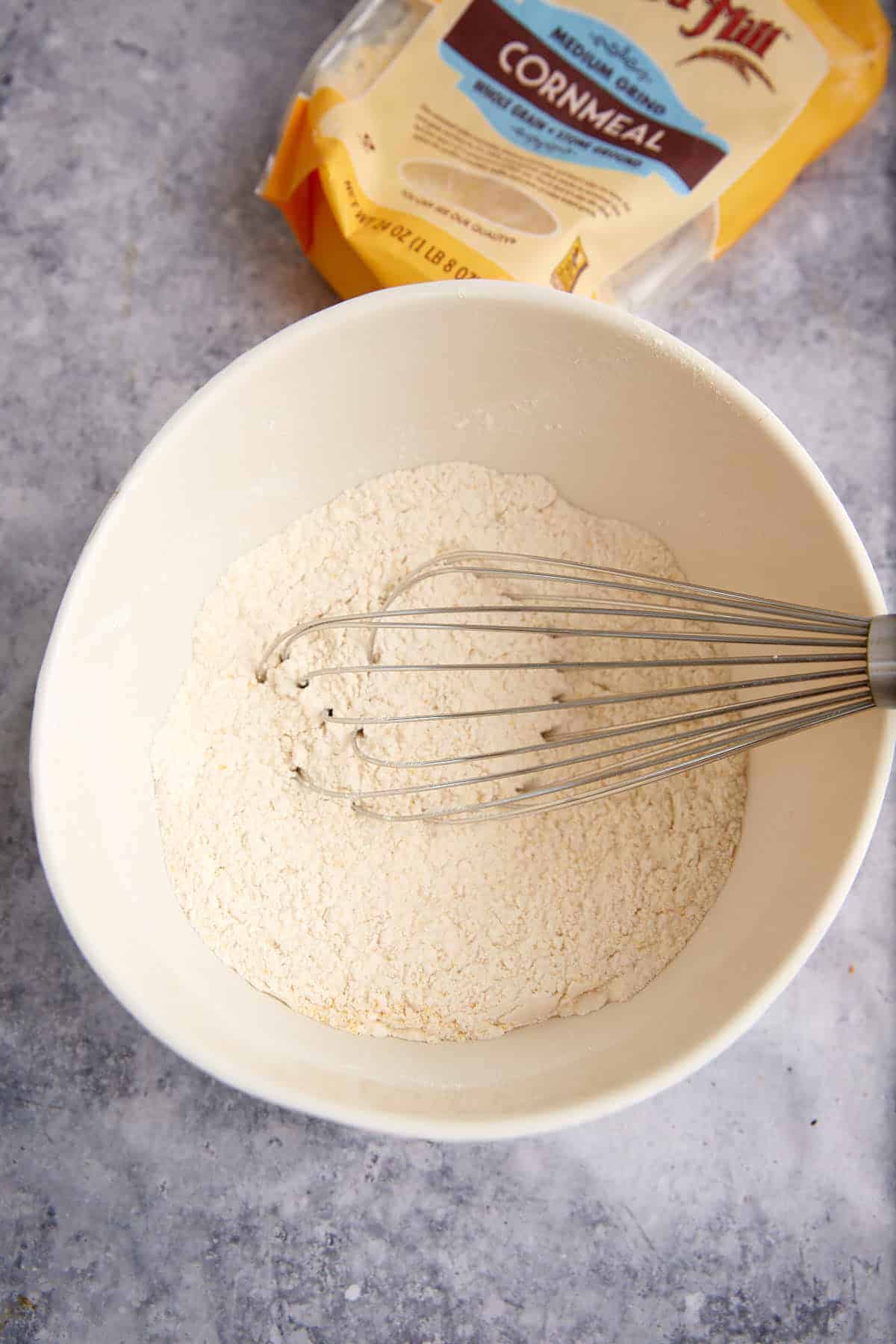 Dry ingredients with a whisk in a bowl.
