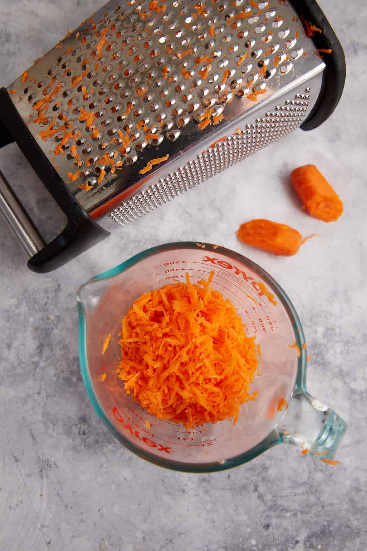 Grated carrots in a measuring cup.