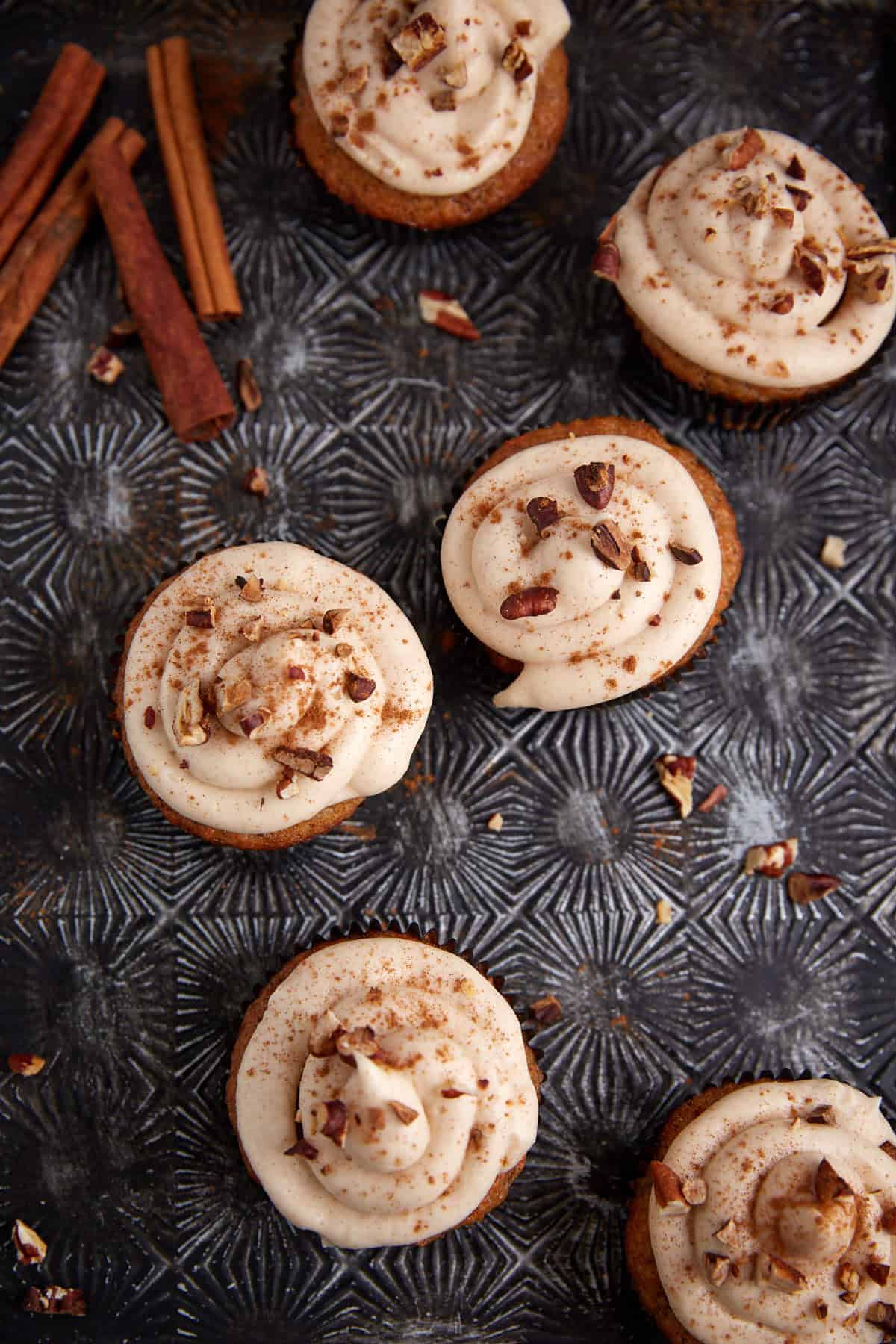 A tray with frosted banana carrot cake cupcakes.