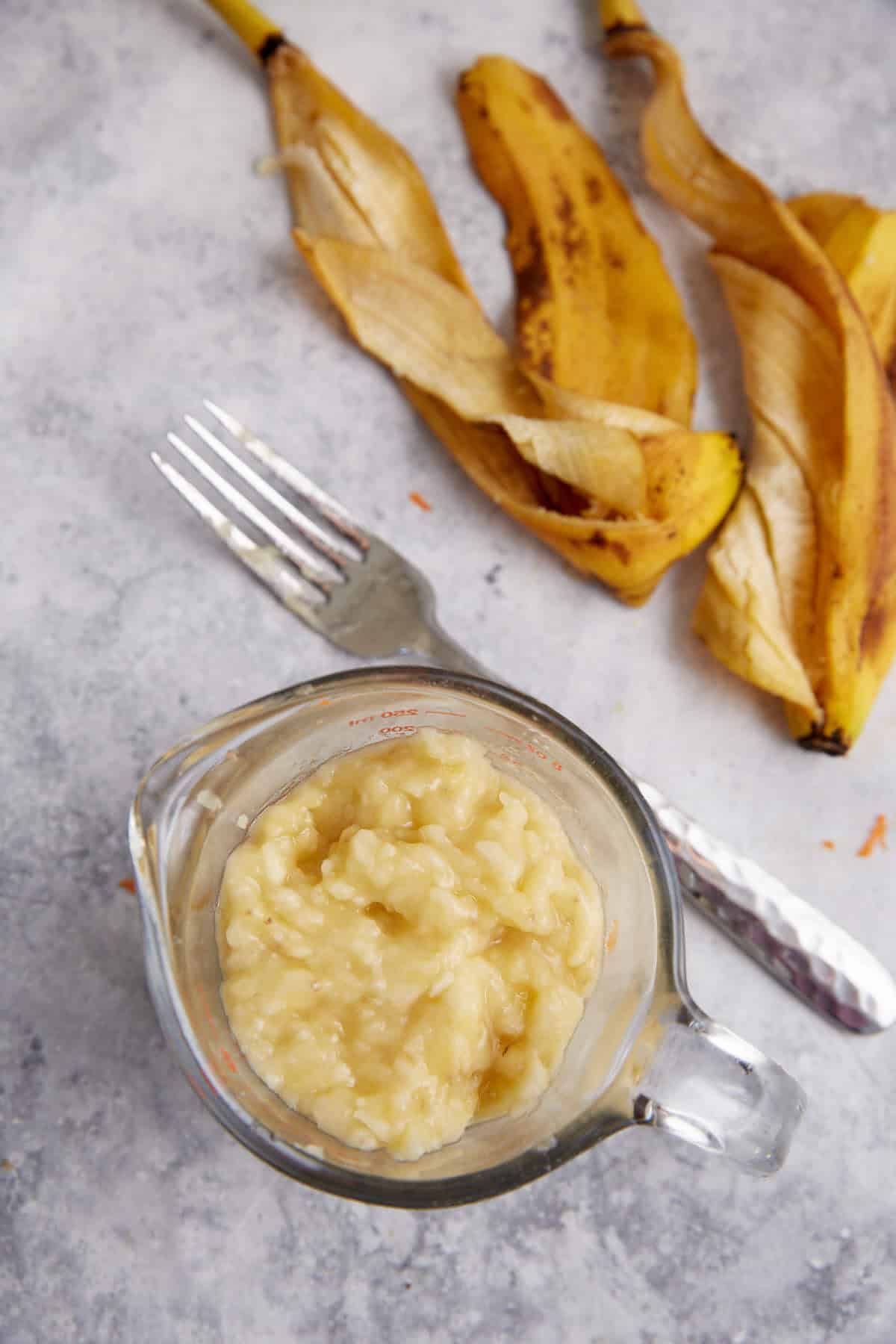 Mashed bananas in a measuring cup.