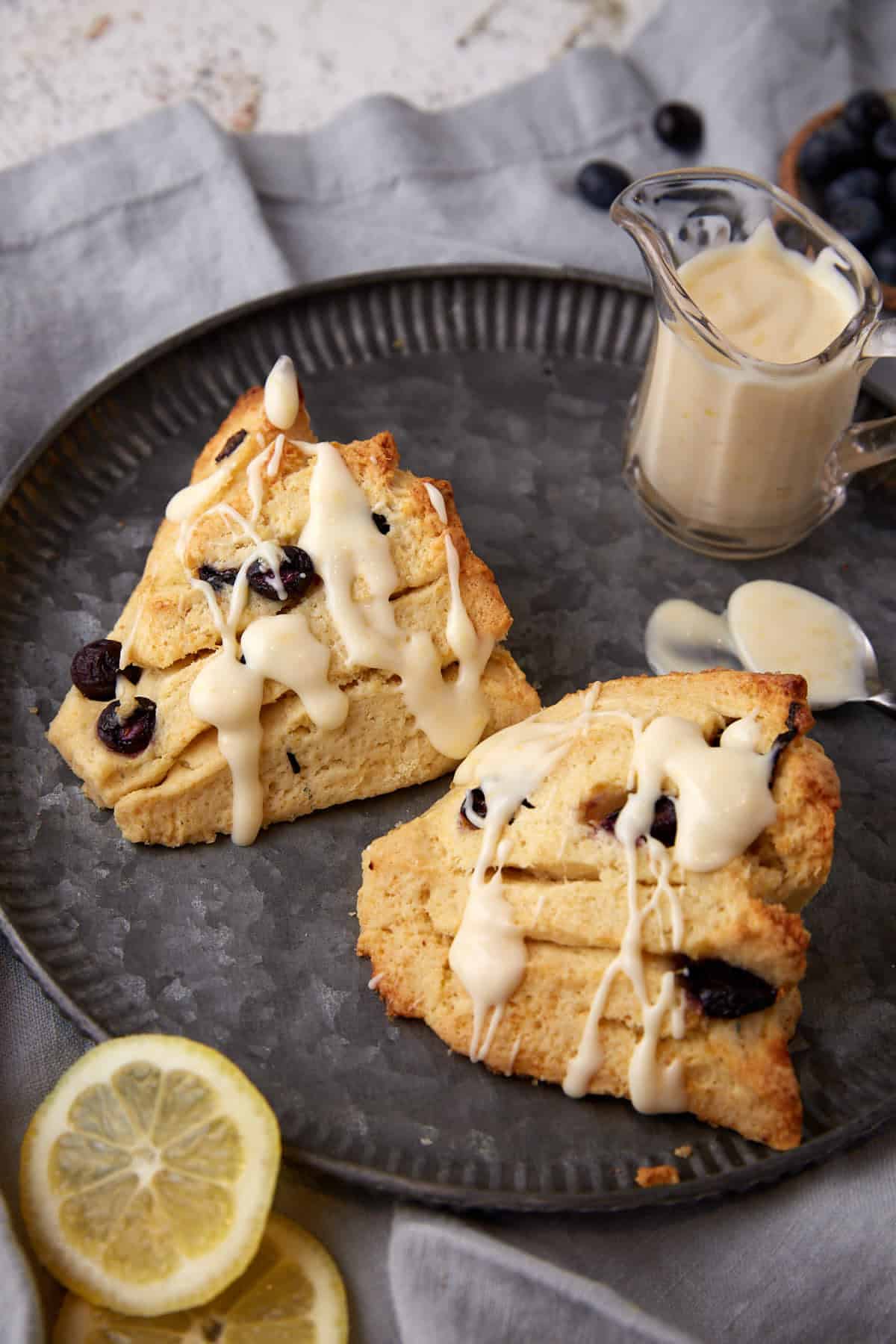 two blueberry scones drizzled with glaze.