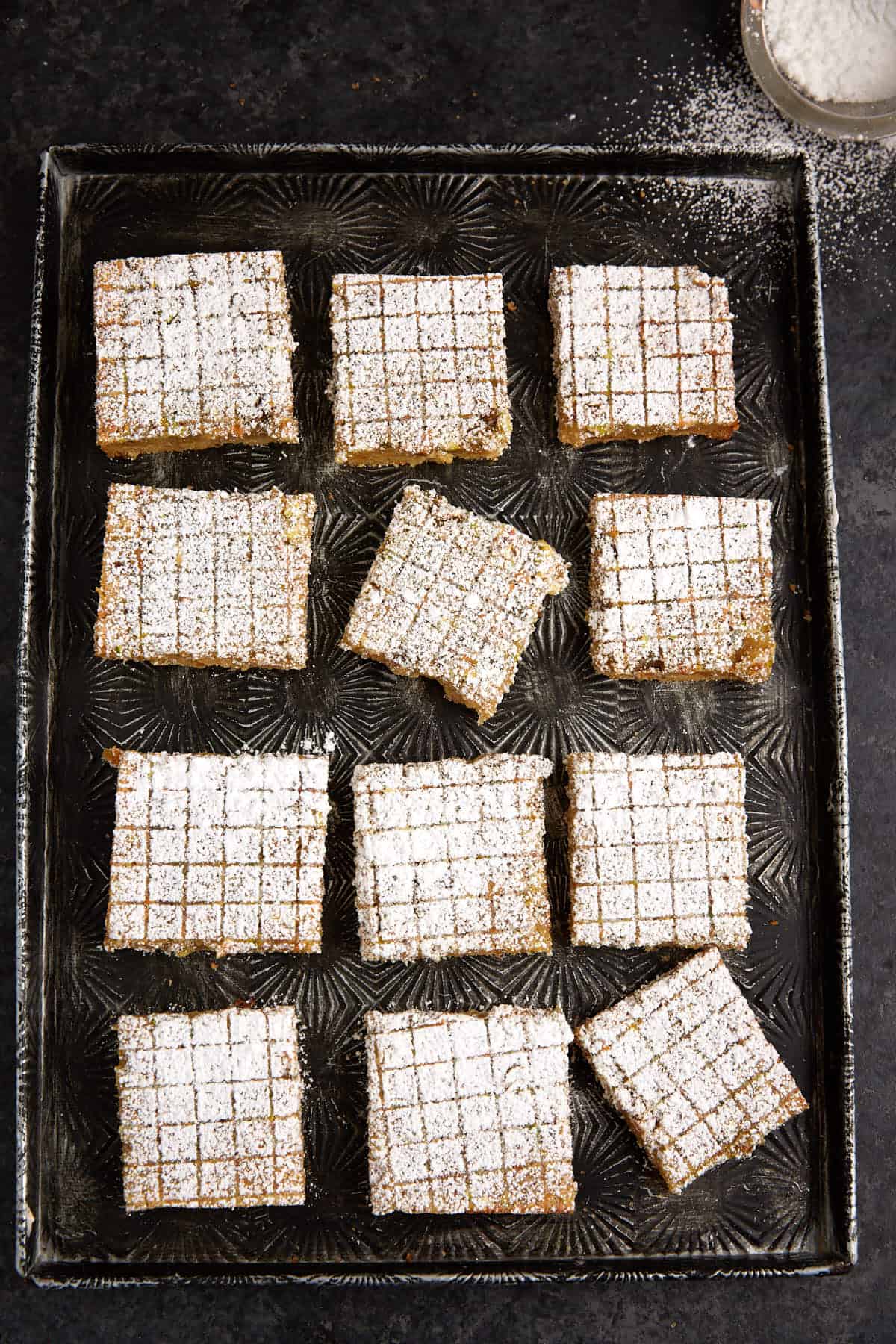 Decorate pistachio lemon bars on a tray.