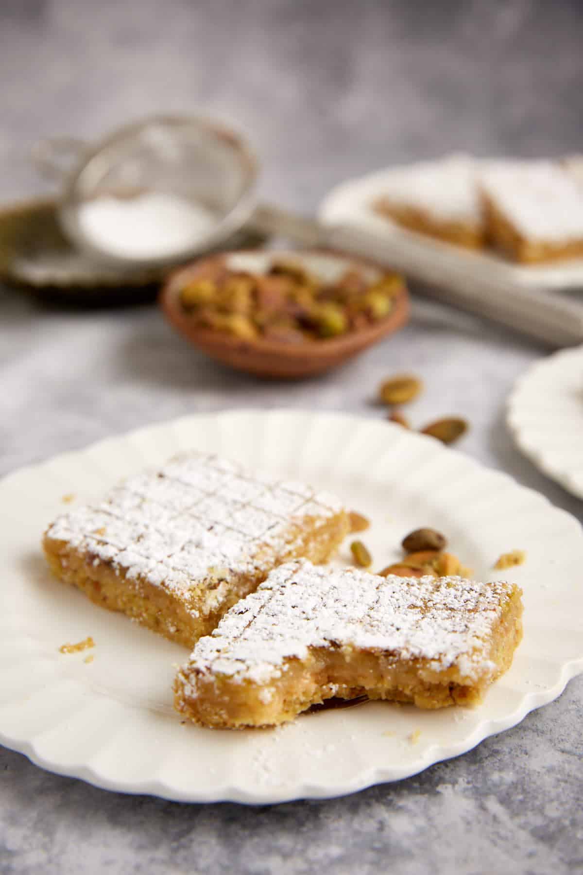 A lemon pistachio bar with a bite taken out.