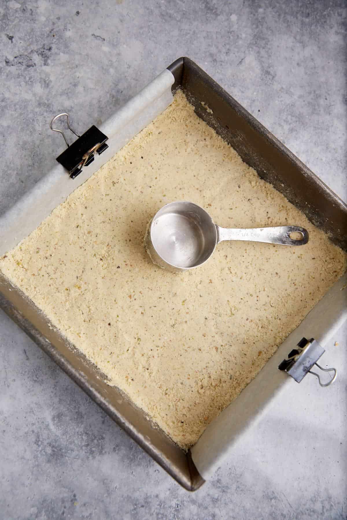 Shortbread dough being patted into a pan.