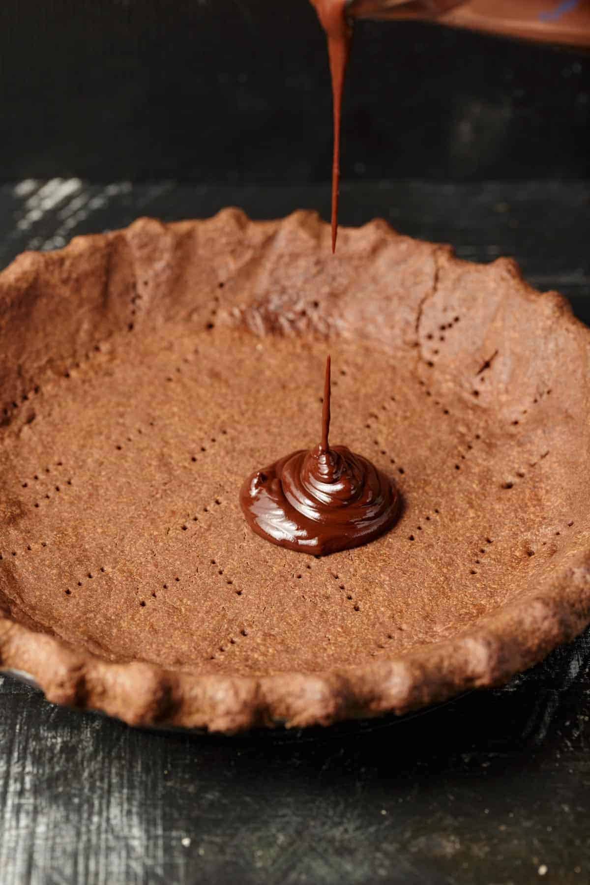 Ganache being added to a pie crust.