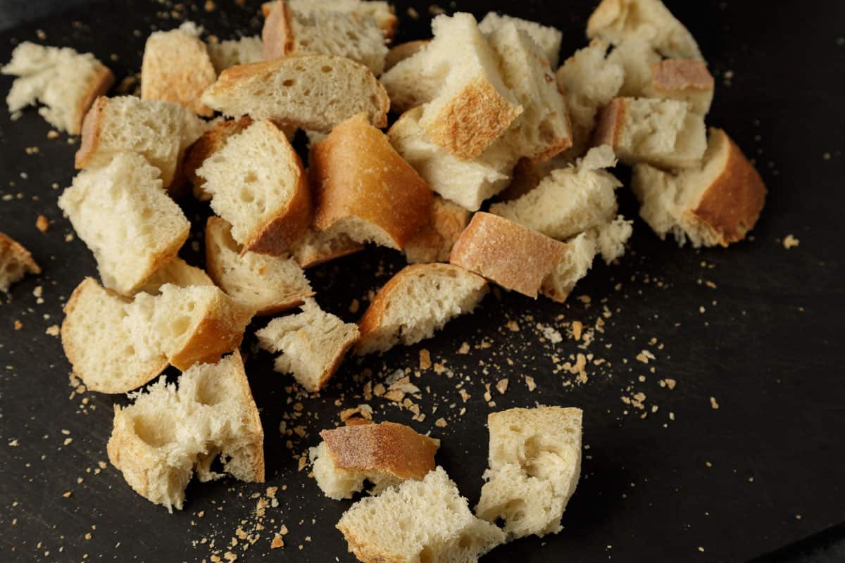 Cubed bread on a cutting board.