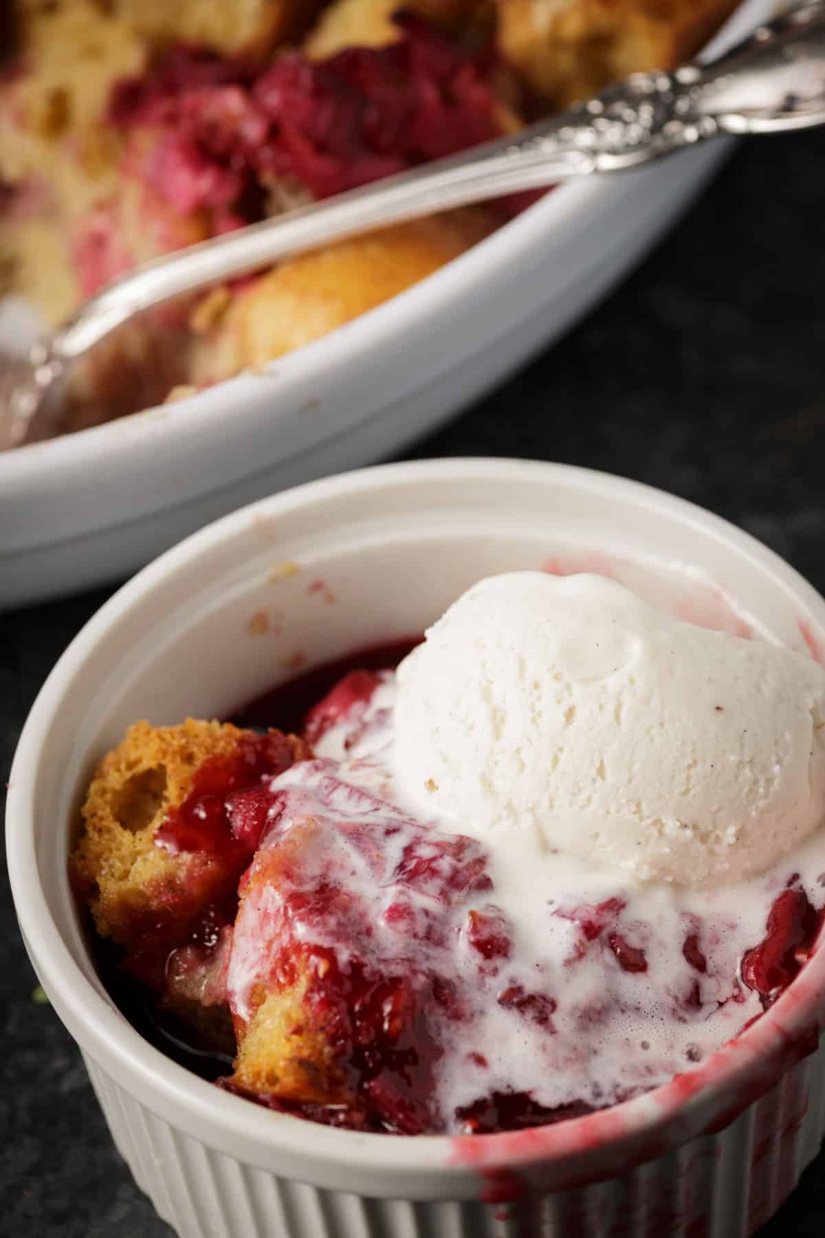 Vanilla ice cream on top of rhubarb bread pudding.