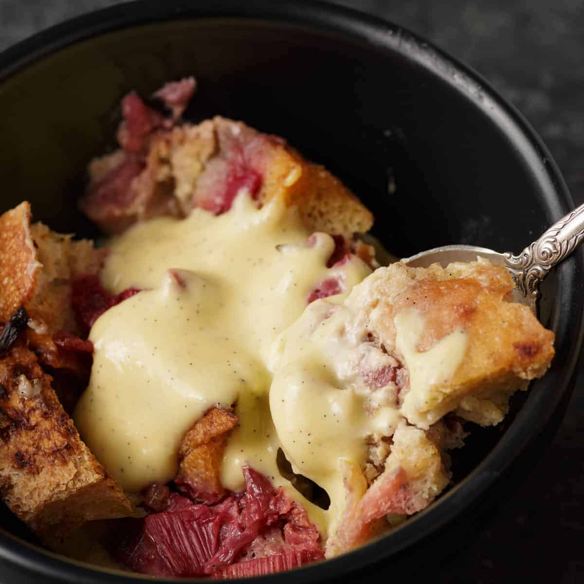 A spoon full of rhubarb bread pudding.