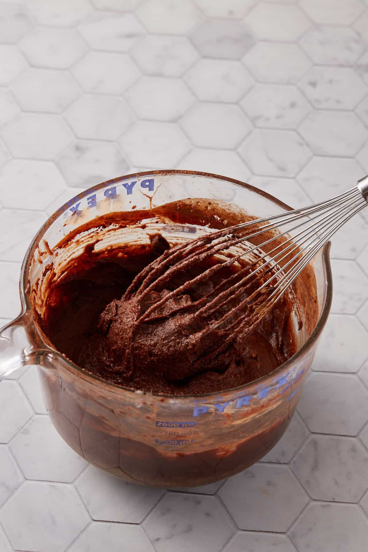Brownie batter being whisked in a bowl.