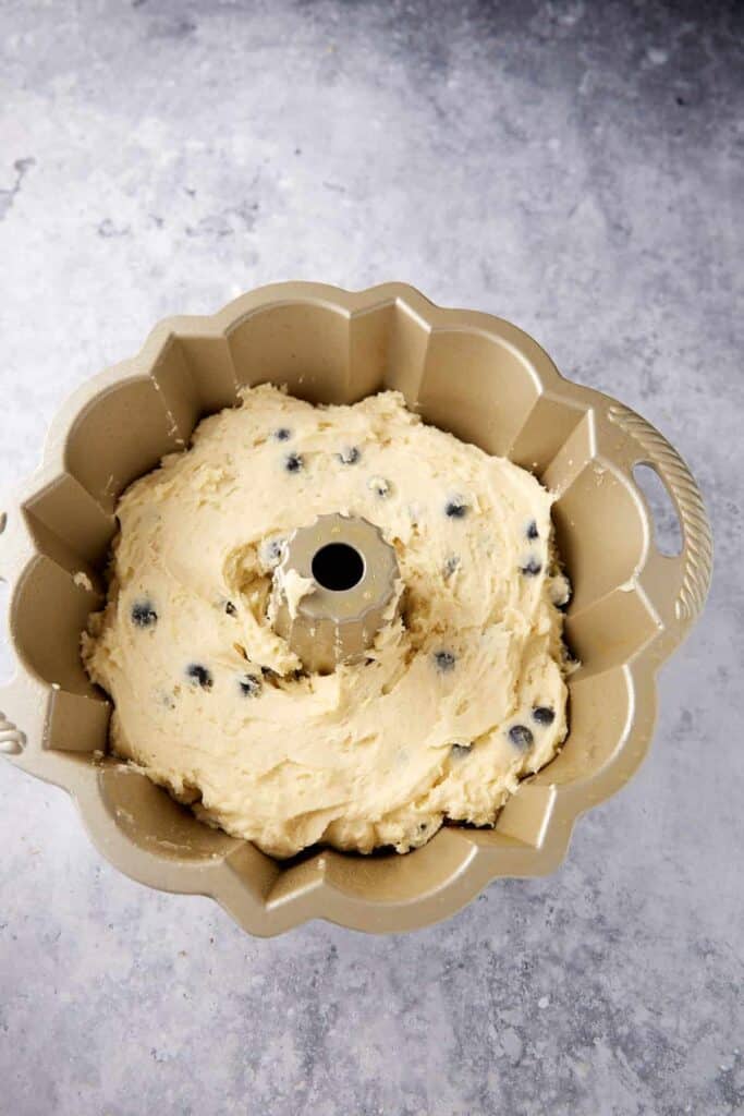 Batter in a bundt pan for a blueberry cake.