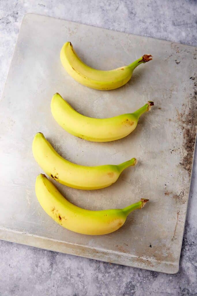 Greenish bananas o a kcookie sheet.