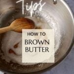 A saucepan with a wooden spoon stirring brown butter.