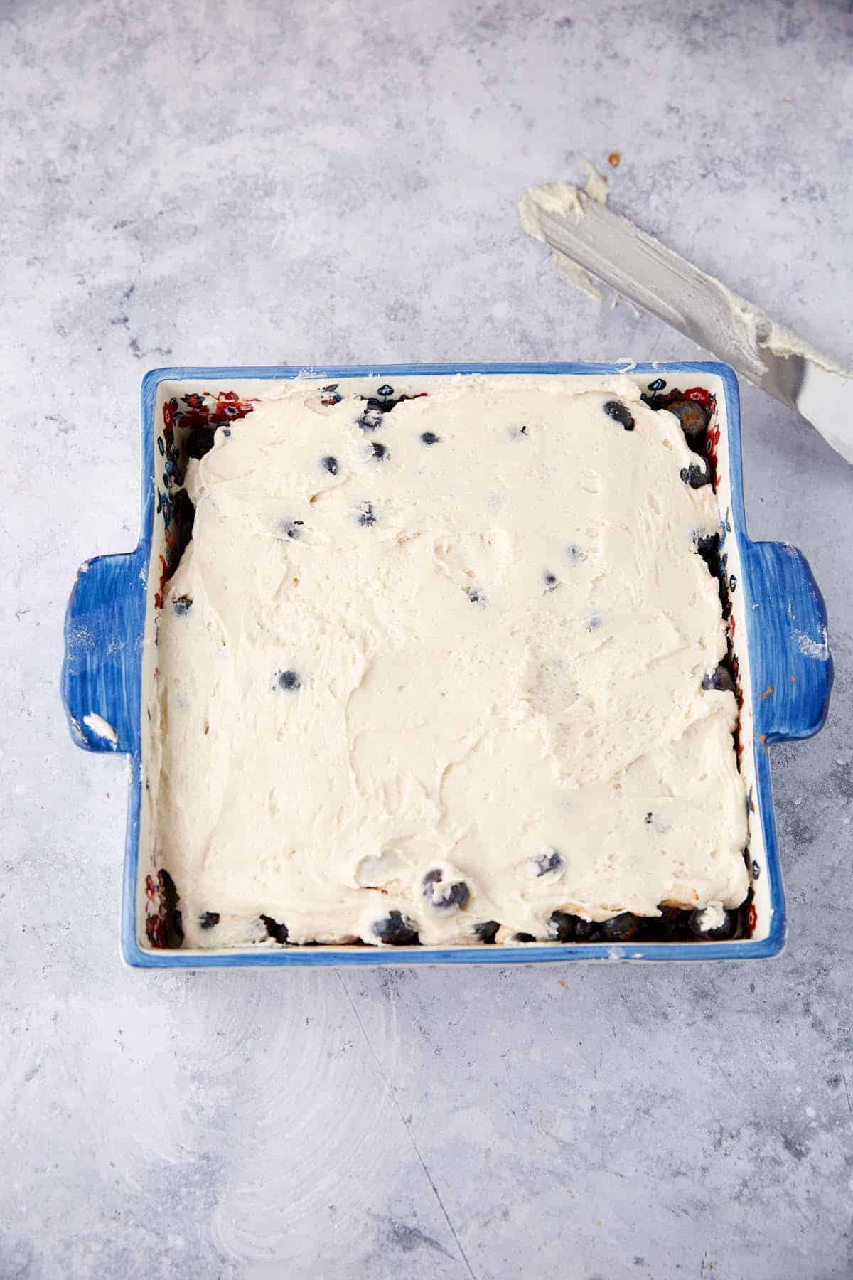blueberry pudding cake layered in a baking dish.
