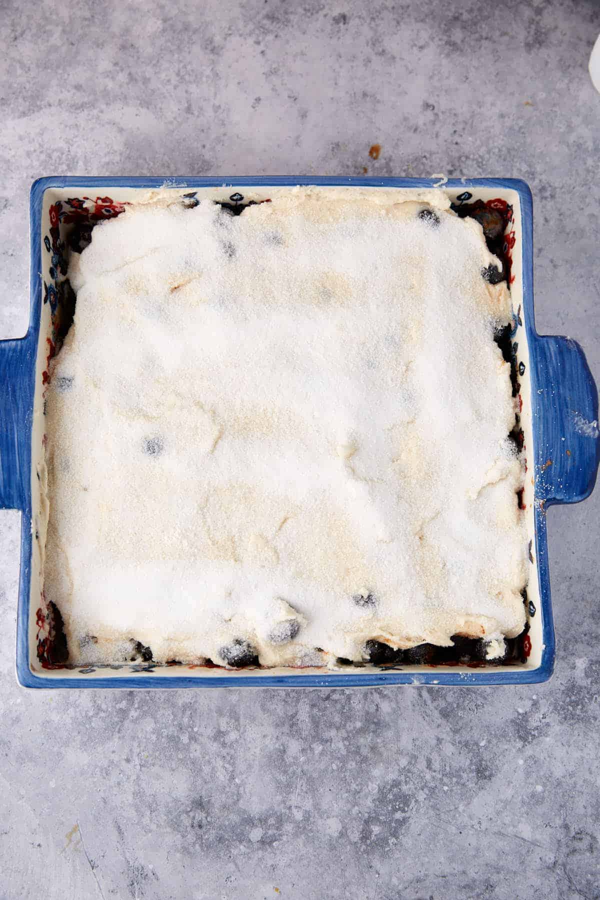 Sugar sprinkled on top of the blueberry pudding cake.