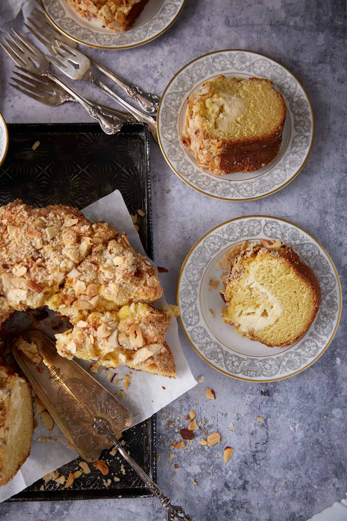 A coffee cake sliced with two slices on plates.