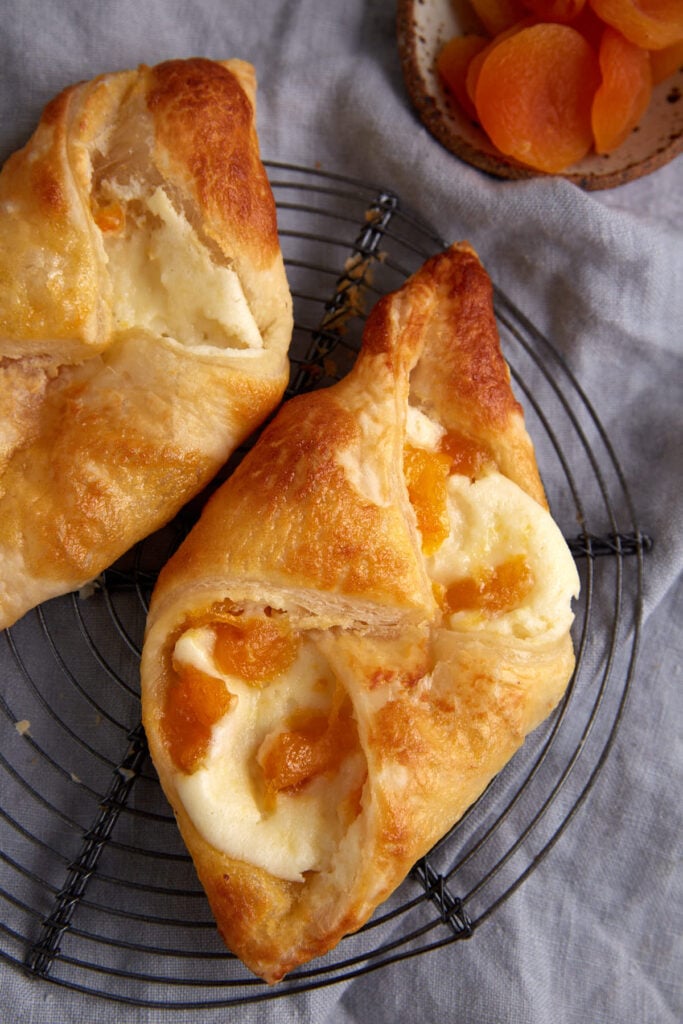 Two cream cheese pastries on a rack.