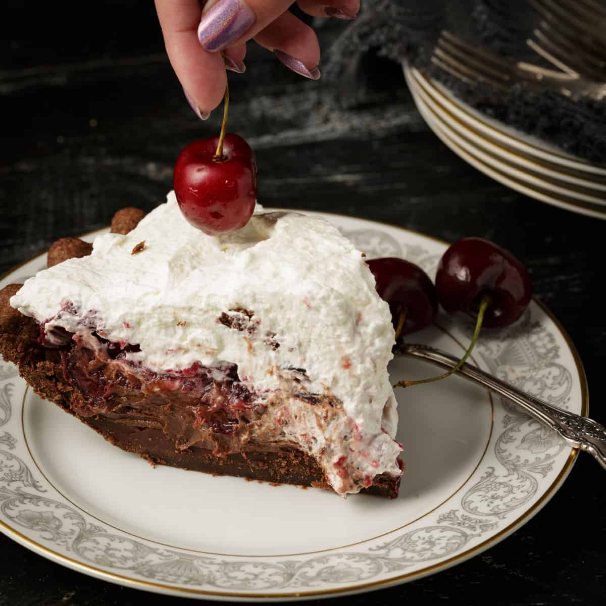 A slice of black forest pie with a cherry on top.