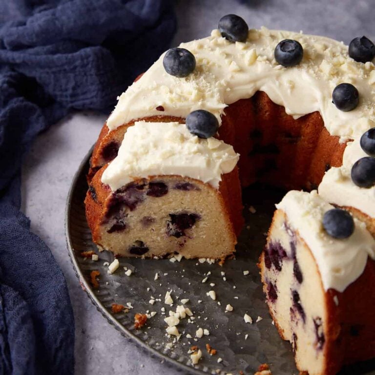 A blueberry bundt cake with slices removed.