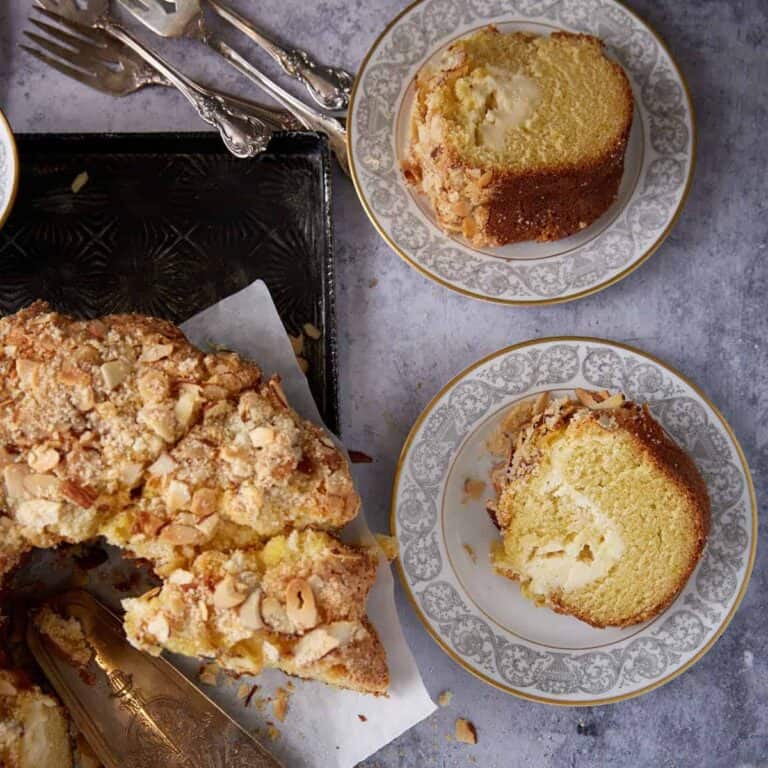 Cream cheese coffee cake sliced on a platter.