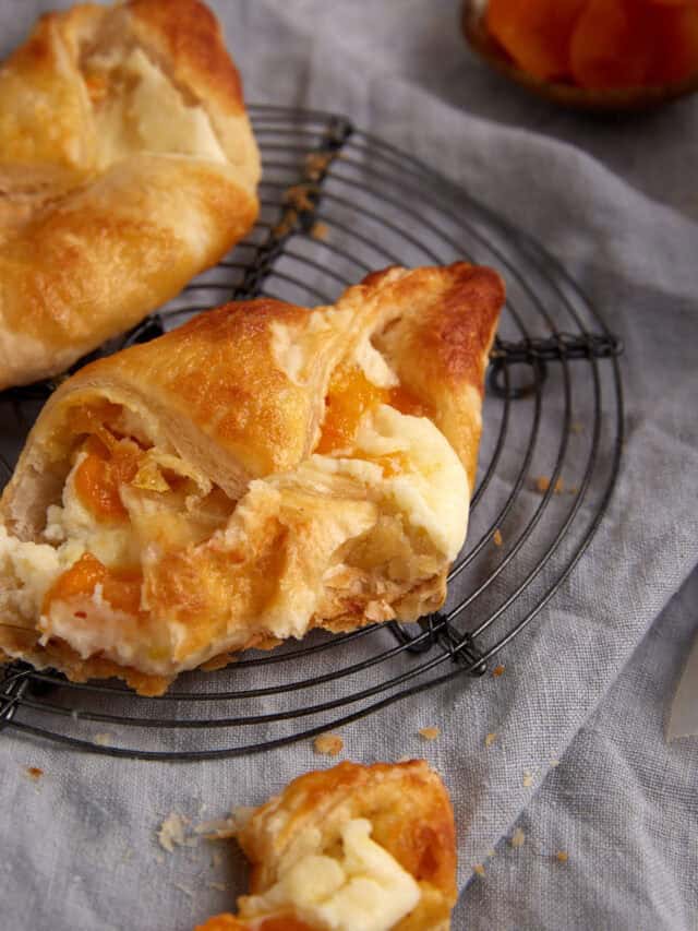 An apricot danish with a bite taken out.