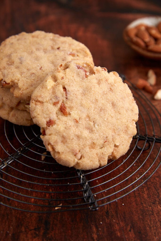 Two almond butter cookies on a cooling rack.
