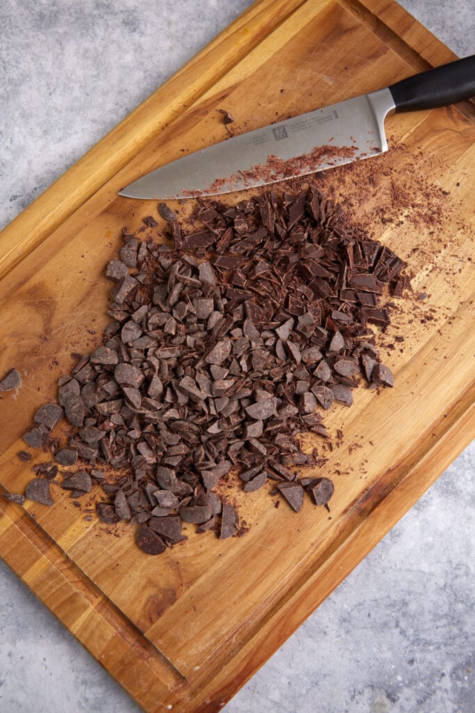 Chopped chocolate on a cutting board.