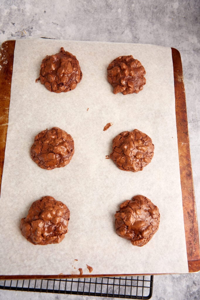 Baked chocolate cookies on a cookie sheet.