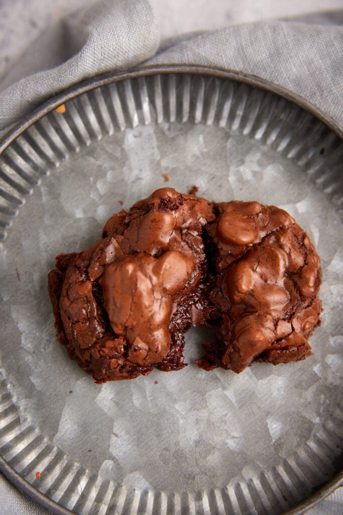 A single chocolate chunk cookie being pulled apart.