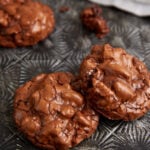 Two chocolate cookies on a tray.