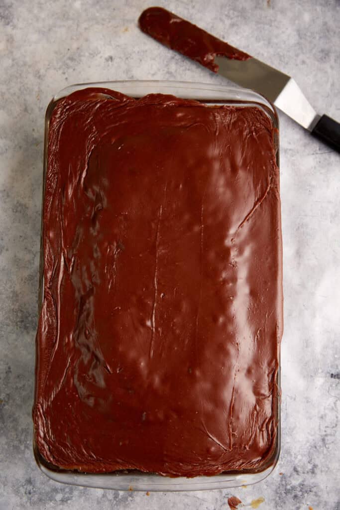 Frosting spread over a coke cake.