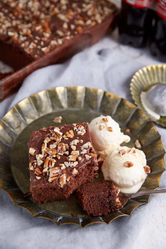 A piece of chocolate cake next to scoops of ice cream.