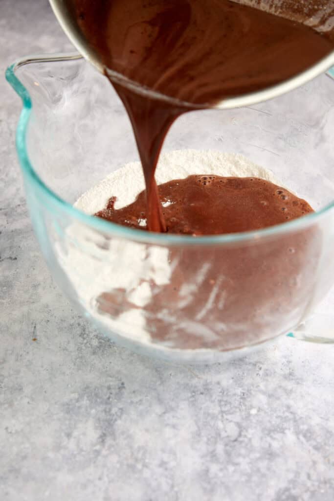 Chocolate mixture being poured over the dry ingredients.