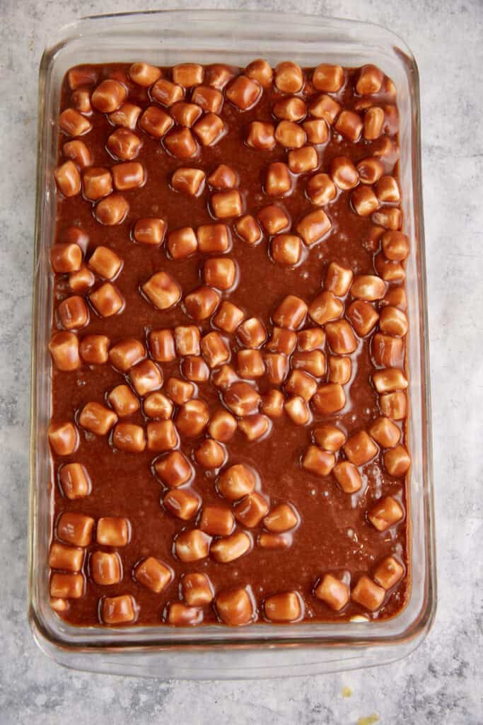 Chocolate batter in a baking dish with marshmallows.
