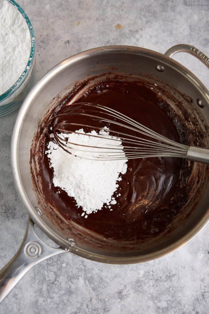 Powdered sugar being added to the frosting.