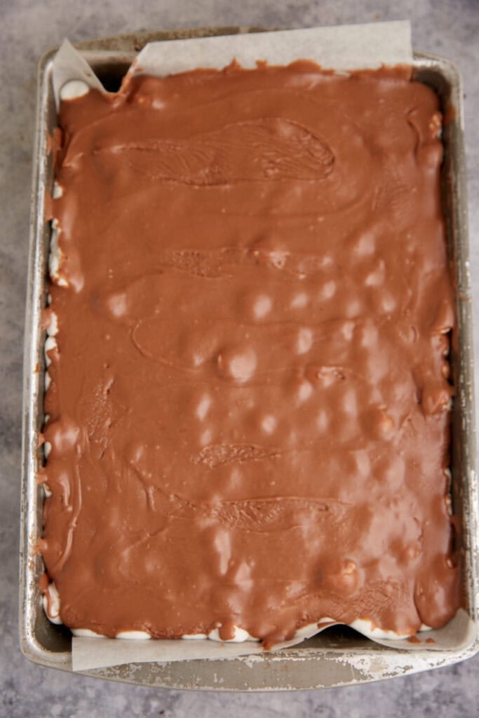 Chocolate frosting spread over the top of a cake.