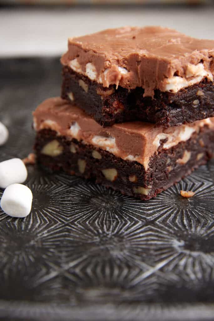 Two brownies with a bite taken out of one.