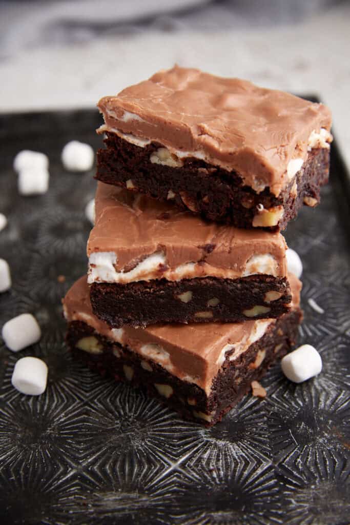 Three brownies stacked on a tray.