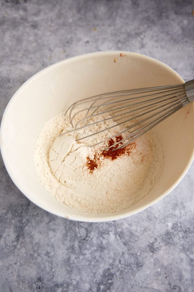 The dry ingredients in a bowl with a whisk.
