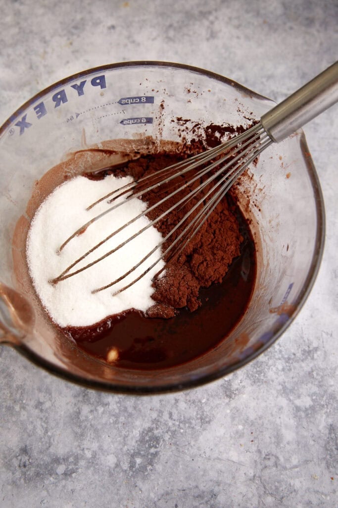 Sugar and cocoa added to melted chocolate.