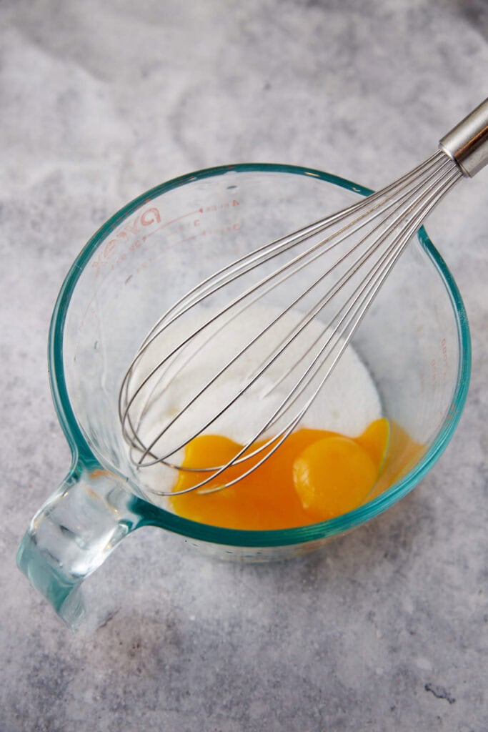 Eggs and sugar in a mixing bowl.