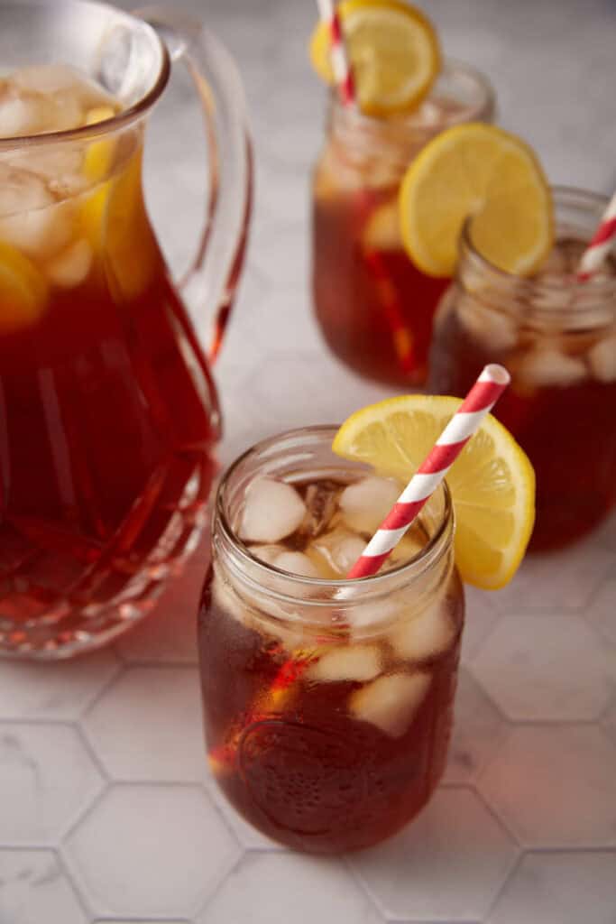 A pitcher and three glasses of sweet tea.