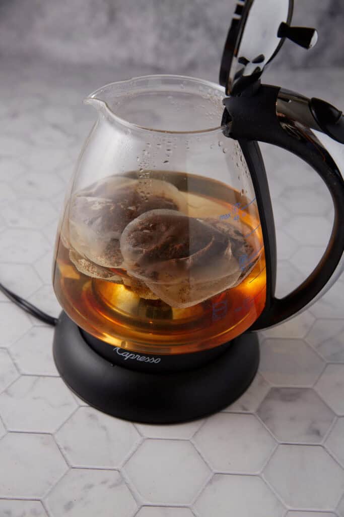 A water kettle with tea bags.
