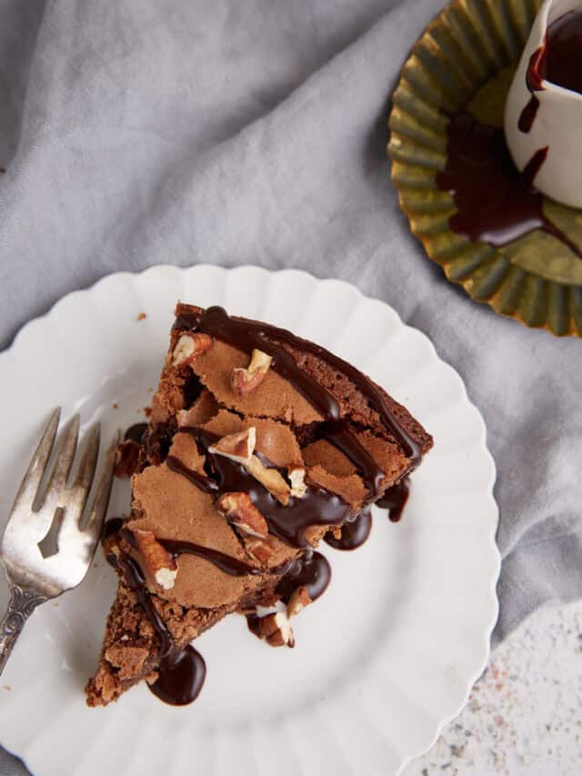 A slice of fudge pie iwth a fork on a plate.