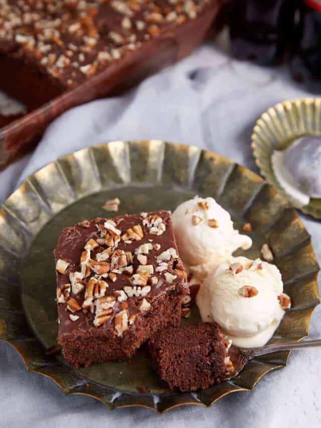A piece of chocolate cake next to scoops of ice cream.