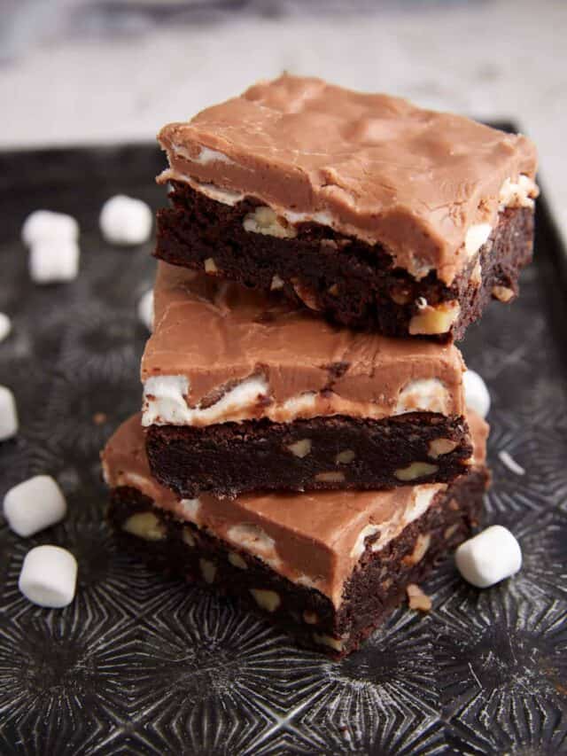 Three brownies stacked on a tray.